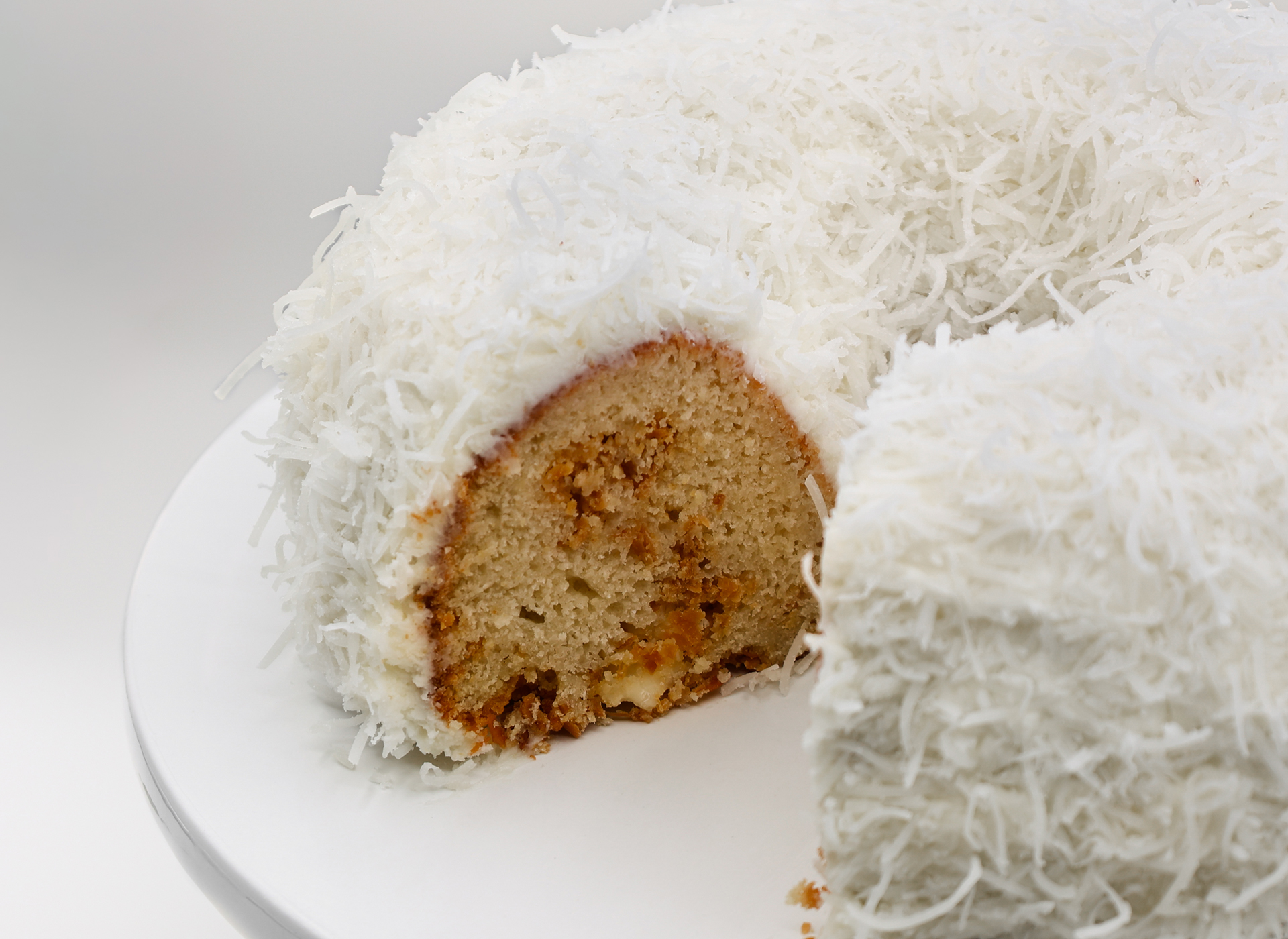 Coconut Cloud Cake on a plate with white background